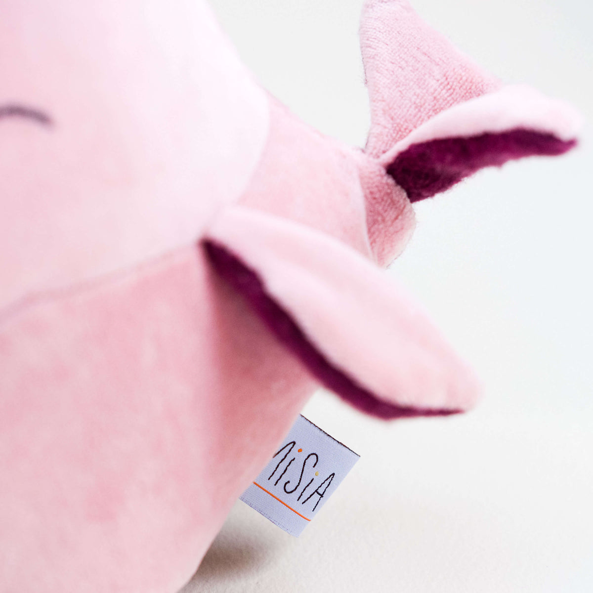 Vista de detalle de Ballena de amor. Muñeco de peluche hecho a mano con telas y relleno de algodón orgánico y ecológico.