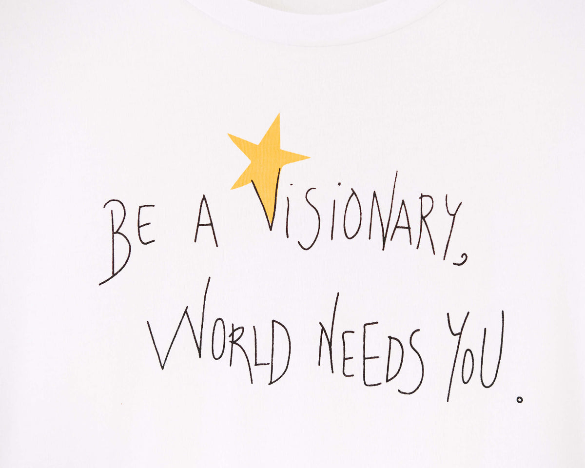 Detalle de texto serigrafía en color negro, y amarillo. Camiseta blanca de mujer, de algodón orgánico y estampado a mano con tintas ecológicas.