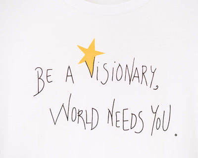 Detalle de texto serigrafía en color negro, y amarillo. Camiseta blanca de mujer, de algodón orgánico y estampado a mano con tintas ecológicas.