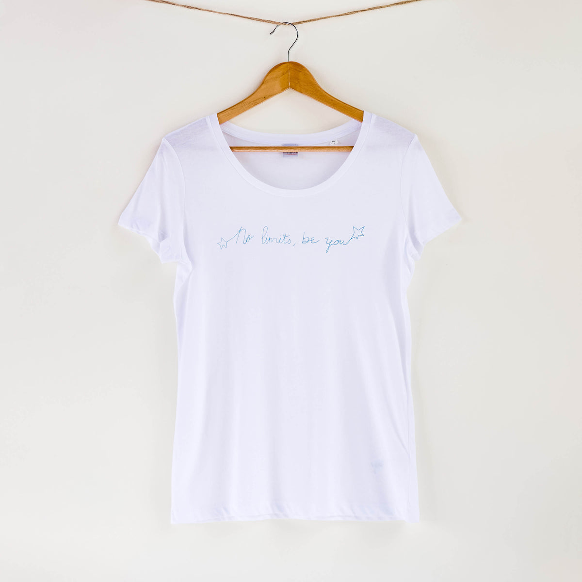 Camiseta blanca de mujer, de algodón orgánico y estampada a mano con tintas ecológicas. Texto estampado en color azul.