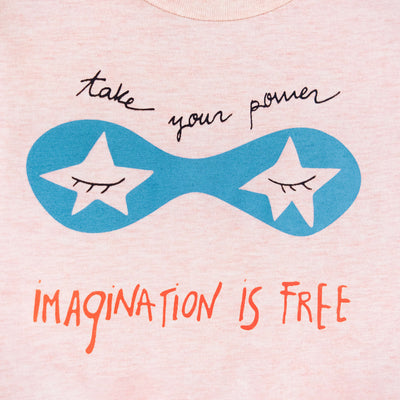 Detalle de texto serigrafía en color negro, azul y naranja. Camiseta rosa de algodón orgánico para niños, estampado a mano con tintas ecológicas. Modelo unisex.