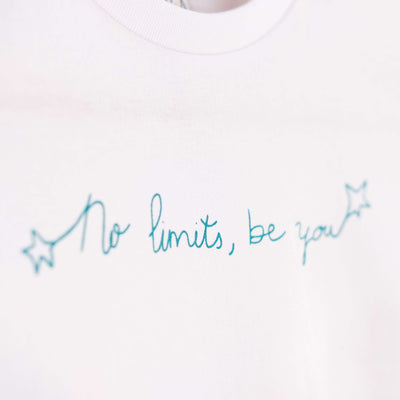 Detalle de texto estampado en color azul. Camiseta blanca de algodón orgánico para niños, estampado a mano con tintas ecológicas. Modelo unisex.