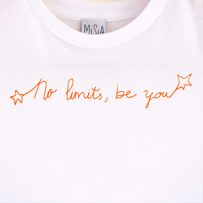 Detalle de texto estampado en color naranja. Camiseta blanca de algodón orgánico para niños, estampado a mano con tintas ecológicas. Modelo unisex.