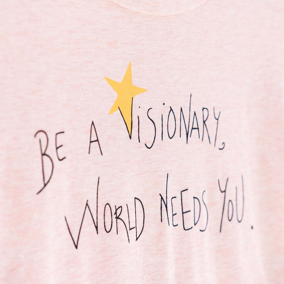 Detalle de texto serigrafía en color negro, y amarillo. Camiseta rosa de mujer, de algodón orgánico y estampado a mano con tintas ecológicas.