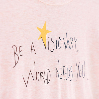 Detalle de texto serigrafía en color negro, y amarillo. Camiseta rosa de mujer, de algodón orgánico y estampado a mano con tintas ecológicas.