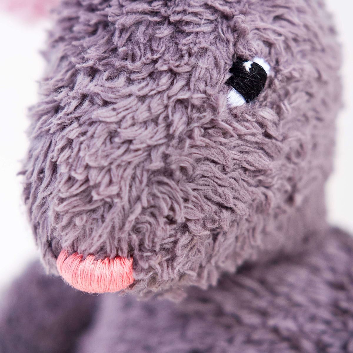 Vista de detalle del conejo Gastón. Muñeco de peluche hecho a mano con telas y relleno de algodón orgánico y ecológico. Bordados a mano.