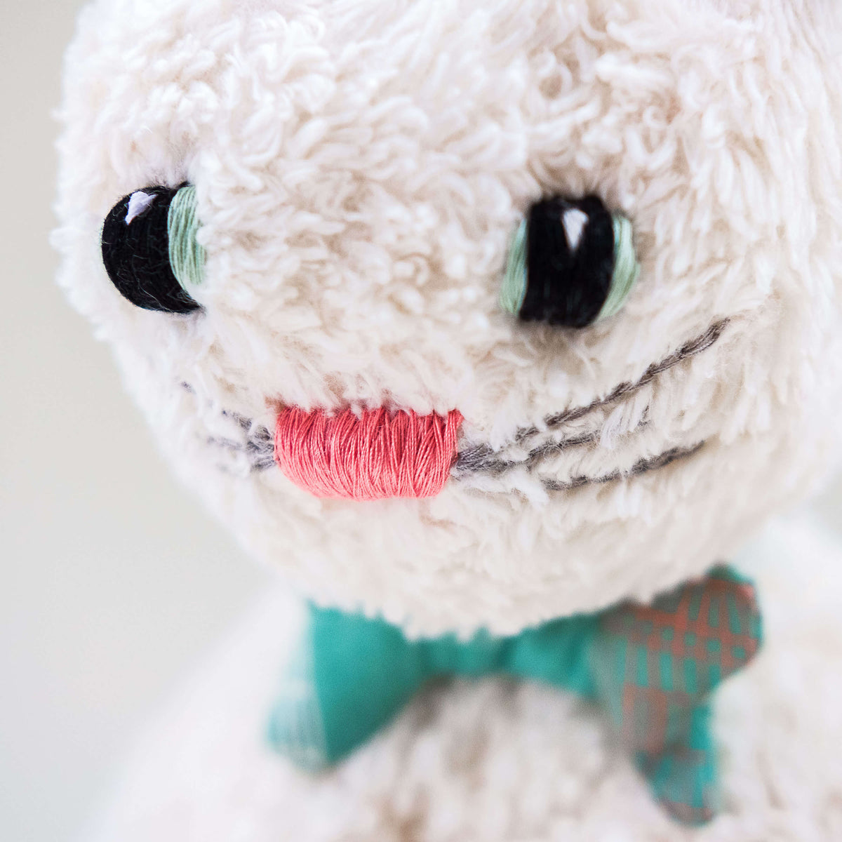 Vista de detalle del gato Max. Muñeco de peluche hecho a mano con telas y relleno de algodón orgánico y ecológico. Detalles bordados a mano.